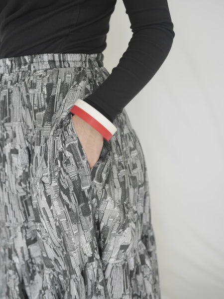 Pocket in side seam view of woman wearing 3 tiered cotton black and white printed skirt, mid calf length, elastic waisted with voluminous hem