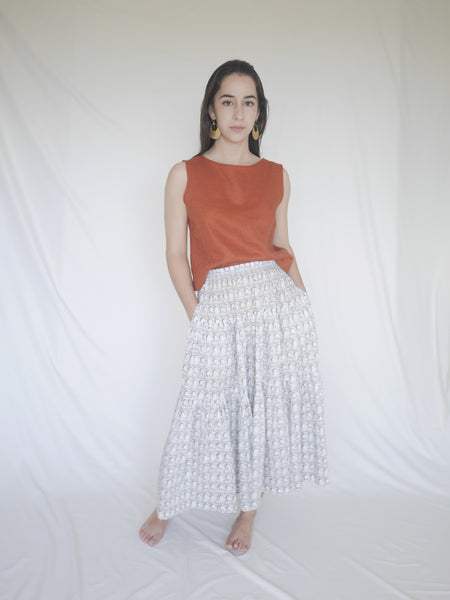 Woman wearing 3 tiered cotton black and white printed skirt, mid calf length, elastic waisted with voluminous hem in Roman arches print