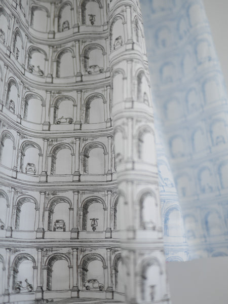 Close up of the Liberty cotton Roman arches fabric in bothe the blue and black colourways showing the  fine pen drawings of arches, cars, mopeds.