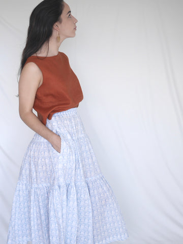 Woman wearing 3 tiered cotton black and white printed skirt, mid calf length, elastic waisted with voluminous hem in Roman arches print